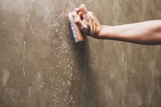 Men's hands are used to convert polishing cleaning on the concrete wall.