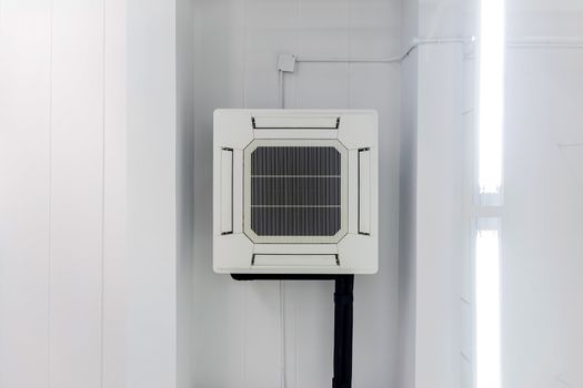 Four-way air conditioner mounted on the ceiling of the room, used for home or office.