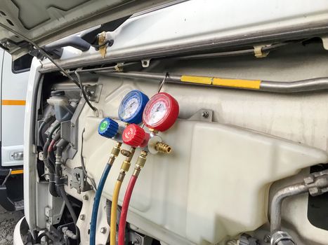 Closeup pressure gauge Car air conditioners hanging in front of trucks.