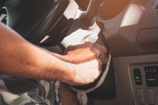 Close up of a man's hand with the key to start the car's engine, transportation and insurance industry concepts.