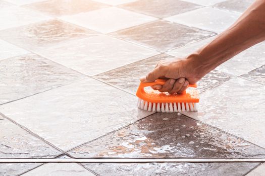 Men's hands are used to convert polishing cleaning on the tile floor.