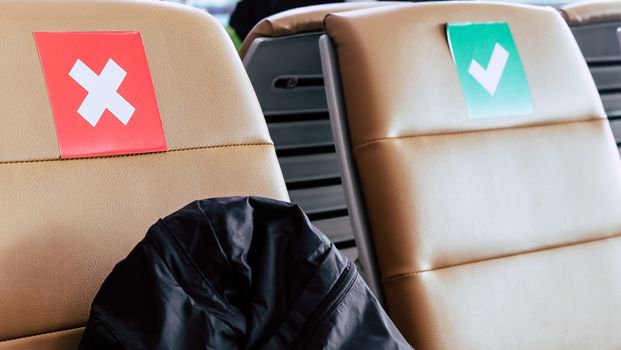 Social distancing, Rows of empty chairs in an airport's departure area marked with symbols regarding social distancing protocol to prevent the spreading of novel corona virus, COVID-19 in Thailand