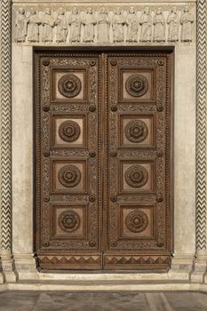 old ornate wooden door with beautiful carvings in italy