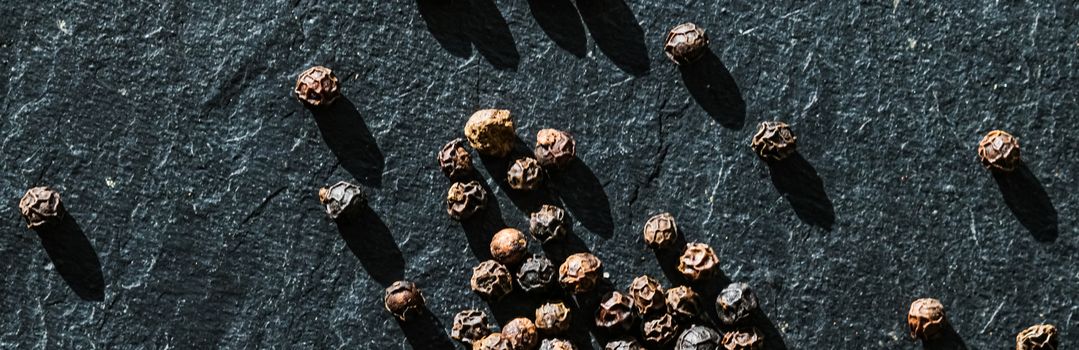 Black pepper closeup on luxury stone background as flat lay, dry food spices and recipe ingredients