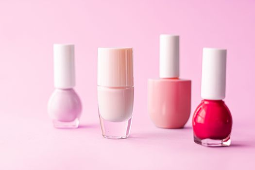 Nail polish bottles on pink background, beauty branding