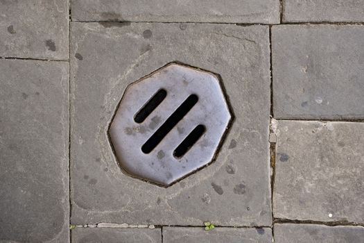 Manhole Cover On Cobbled Road in lucca italy