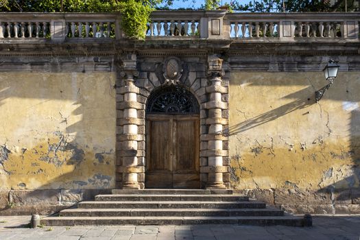 An old doorway with stairs in the city of Lucca, Tuscany, Italy.