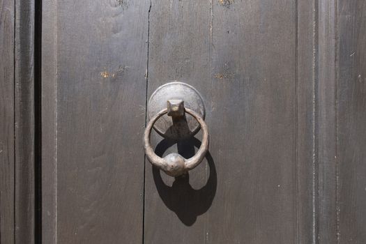 Antique door knocker on wooden door. Vintage, retro background