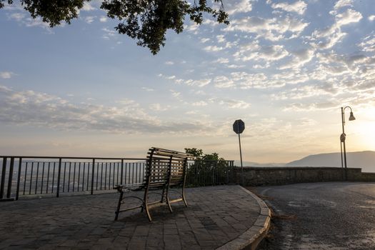 Lonely bench with breathtaking panoramic view in the morming sun in Umbria, Italy