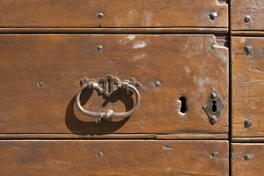 Antique door knocker on wooden door. Vintage, retro background