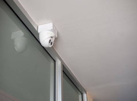 CCTV is located on the wall under the white ceiling.