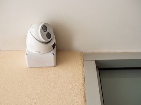 CCTV is located on the wall under the white ceiling.