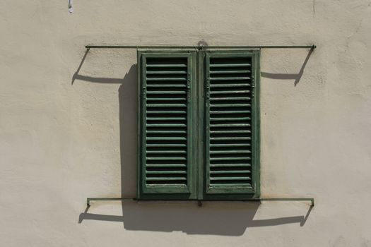 Green window shutters and a concrete grunge wall background.