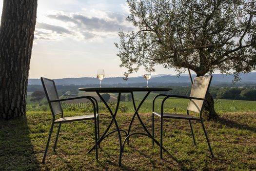Tables and chairs outside the winery in tuscany in summer at sunset, Italy