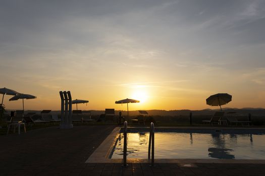 Tropical swimming pool at sunrise in Umbrua, Italy.