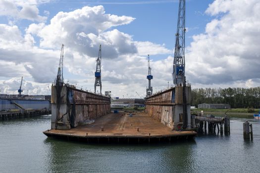 Rotterdam, The Netherlands. Eye level view on an empty floating dry dock with large cranes on the side