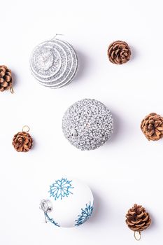 Christmas New Year composition. Gifts, fir tree cones, silver ball decorations on white background. Winter holidays concept. Flat lay, top view