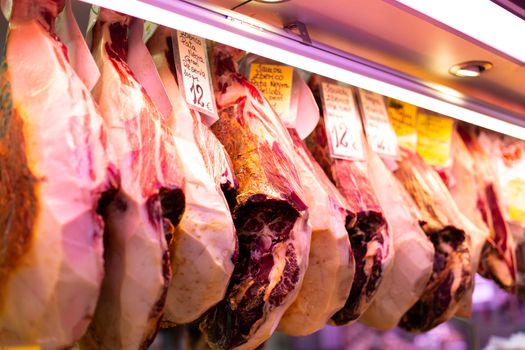 Malaga, Spain - May 24, 2019: Row of ham for sale at the Atarazanas Market.