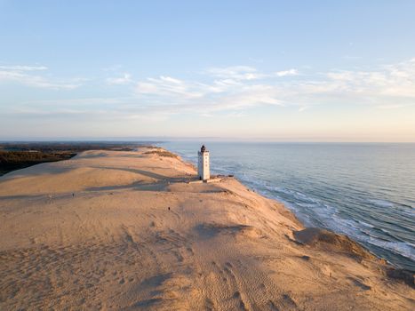 Lokken, Denmark - July 15, 2019: Aerial drone view of Rubjerg Knude Lighthouse and sand dunes.