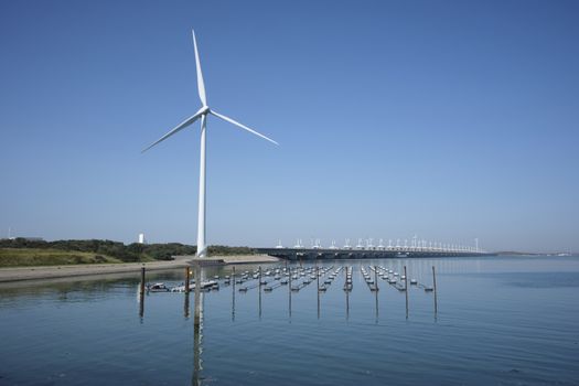 the zeelandbrug deltaworks in holland at the Oosterschelde river to protect holland form high sea level, this is near the dutch museum neeltje jans with windmills as background