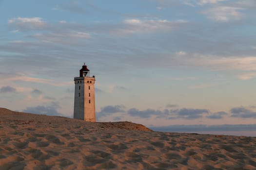 Lokken, Denmark - July 15, 2019: Rubjerg Knude Lighthouse and sand dunes during sunset time.