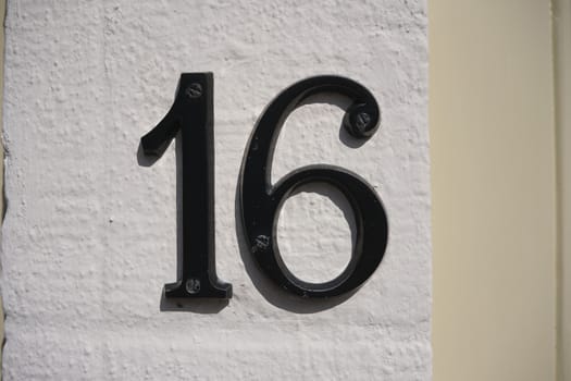 House Number 16 sign on wall.