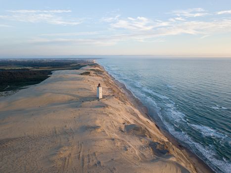 Lokken, Denmark - July 15, 2019: Aerial drone view of Rubjerg Knude Lighthouse and sand dunes.