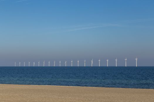 Copenhagen, Denmark - October 11, 2018: Amager Beach Park with row of offshore wind power plants in the background