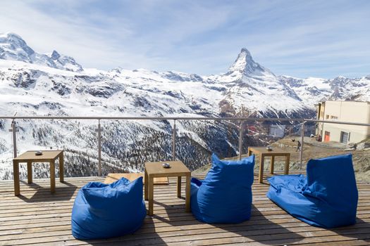 Zermatt, Switzerland - April 12, 2017: Empty chair cushions in a bar and restaurant in the Matterhorn skiing area. Famous Matterhorn in the background.