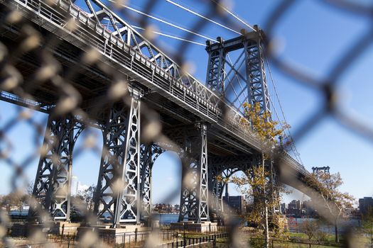 Abstract view through fence of Williamsburg Bridge towards Brooklyn in New York City