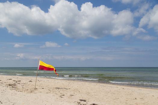 Red and yellow swimming area flag at Tisvilde beach in Denmark.