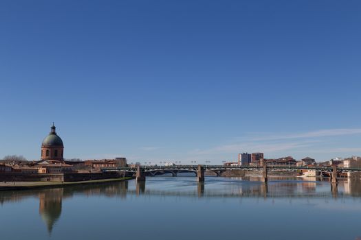 View over Garonne River in Toulouse in France towars bridge Saint-Etienne and dome of the Grave hospital.