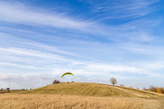 Copenhagen, Denmark - March 28, 2017:  A paraglider trying to start from a small hill just outside the city