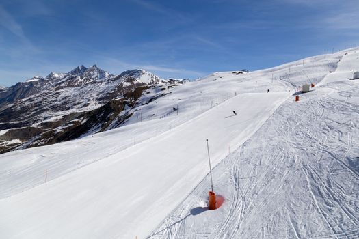 Zermatt, Switzerland - April 12, 2017: Unrecognisable people skiing on an almost empty ski piste in the famous Matterhorn skiing area.