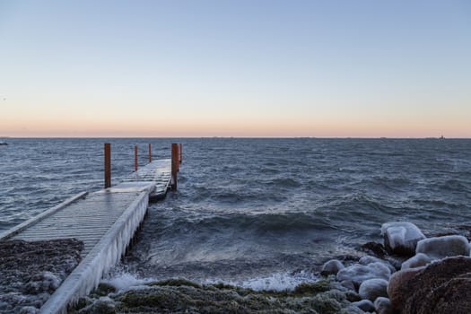 Photograph of a frozen ocean pier at Amager Beach in Copenhagen.