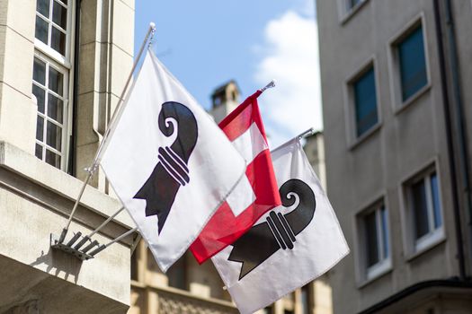 One Swiss flag in between two flags of the swiss canton of Basel