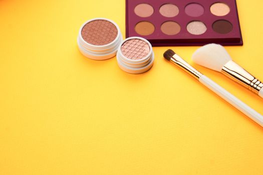 Eyeshadow eye makeup brush on yellow background top view Copy Space. High quality photo