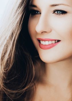 Elegant woman smiling, brunette with long light brown hair, model wearing natural makeup look, female showing healthy white teeth, beauty portrait for cosmetic or lifestyle brands