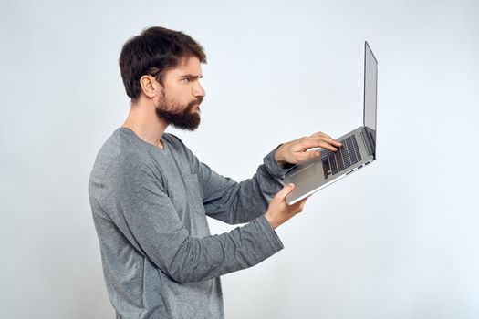 Bearded man with laptop in hands internet communication technology light background. High quality photo