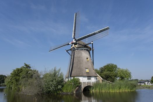Traditional dutch windmill near the canal. Netherlands. Unesco site.