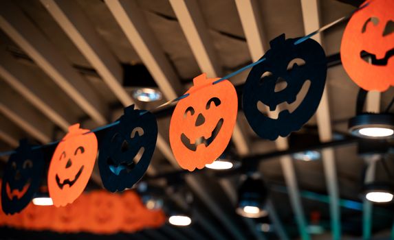 Festive Halloween cartoon decoration hanging on the ceiling of room interior, close up.