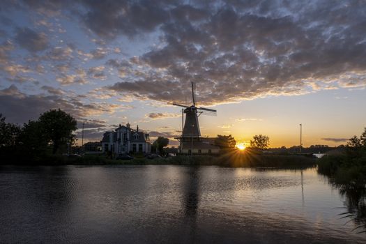 A Sundown with Dutch windmill in the waters of Kralingse Plas, Rotterdam, Netherlands