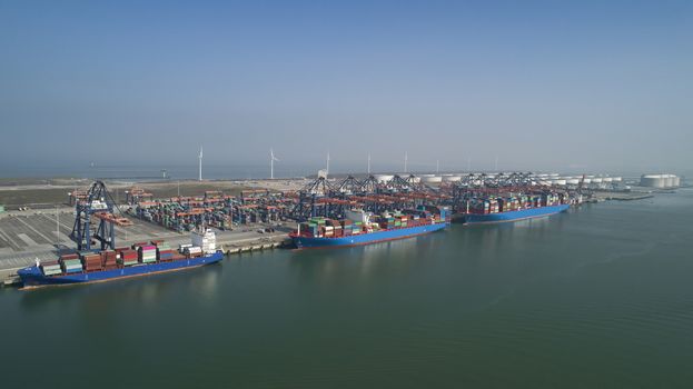 Huge cranes and ships anchored at harbor. International commercial port, city of Rotterdam background. Logistics business