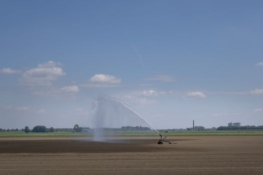 Watering system in a field. An irrigation pivot watering a field