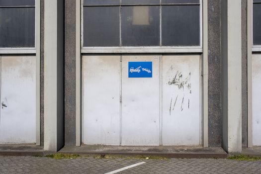 old metal warehouse door, hangar with tow away sign