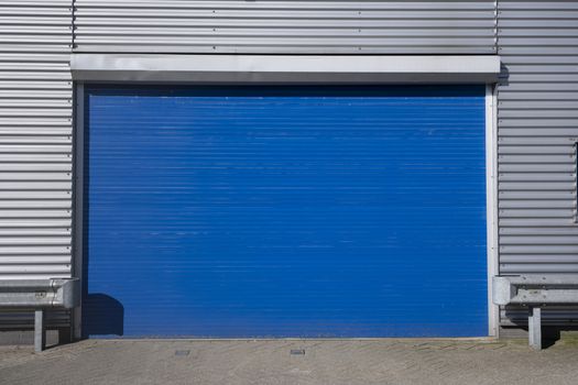 Roller shutter door and concrete floor outside factory building for industrial background.