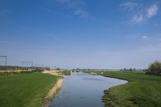 Dutch polder landscape in the spring season with a train track on the left