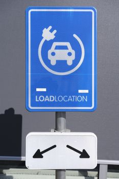 electrical charging station sign conveniently located next to a public parking lot