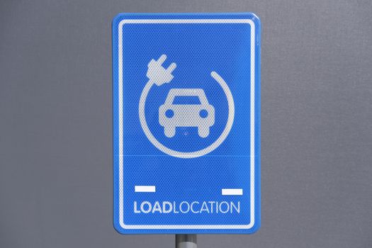 electrical charging station sign conveniently located next to a public parking lot