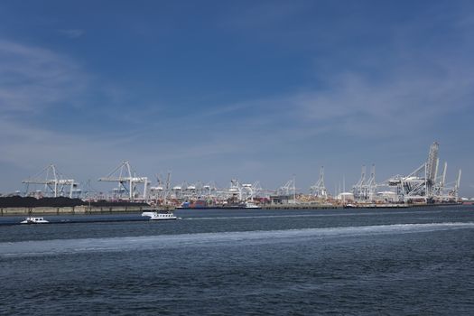 Huge cranes and ships anchored at harbor. International commercial port, city of Rotterdam background. Logistics business